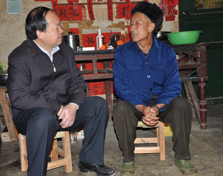 图为卢素理(左)与天生桥镇祥播村下新寨屯贫困党员韦永利亲切交谈.
