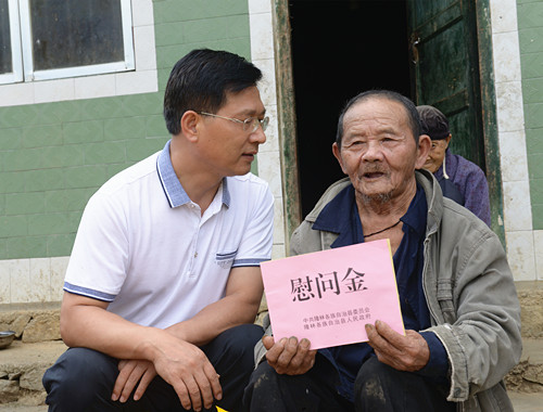 图为黄子锋慰问困难老党员熊正林.